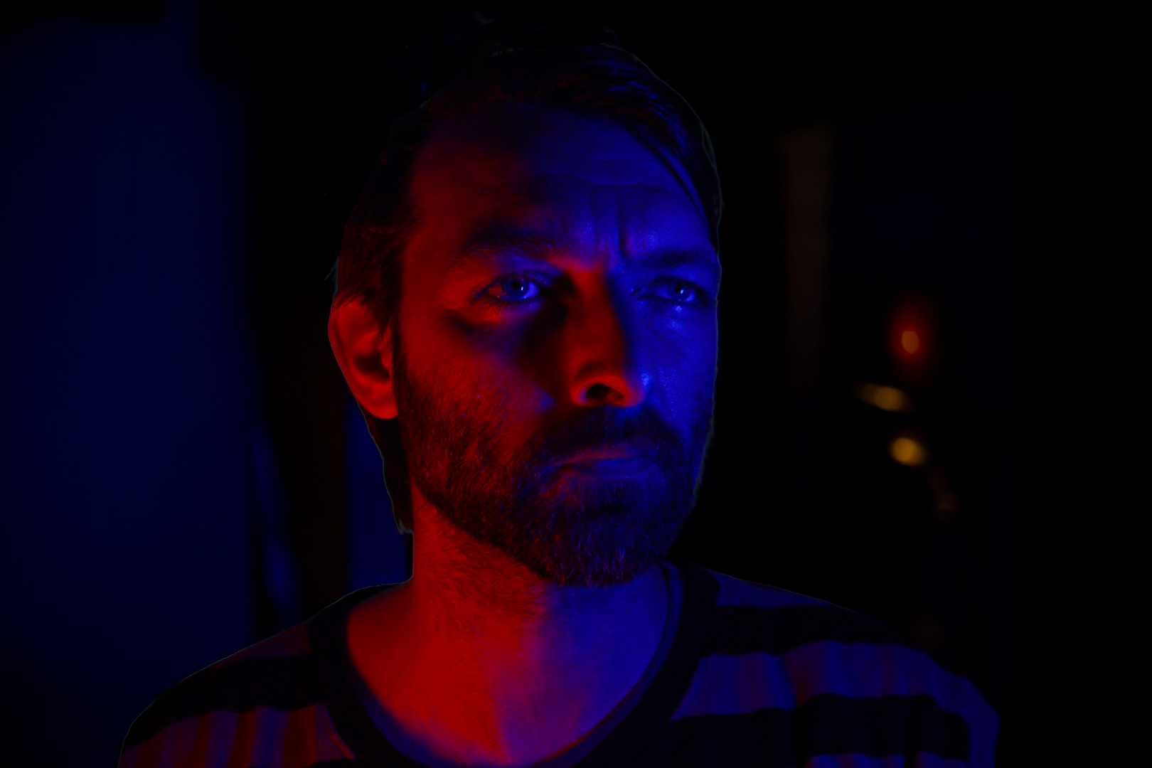 Michael Osborne, visual artist, photographed in blue and red light